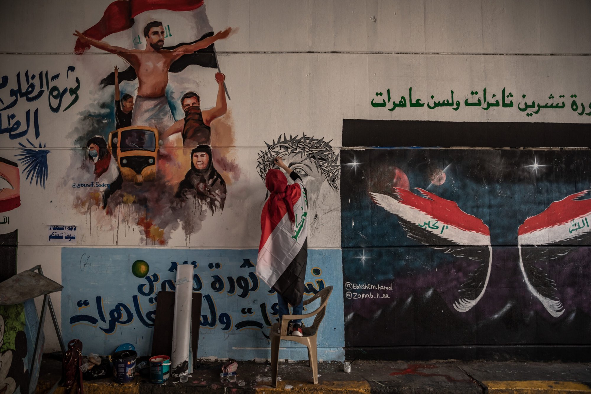 An antigovernment supporter and artist paints a new mural in the underpass underneath Baghdad’s Tahrir Square.