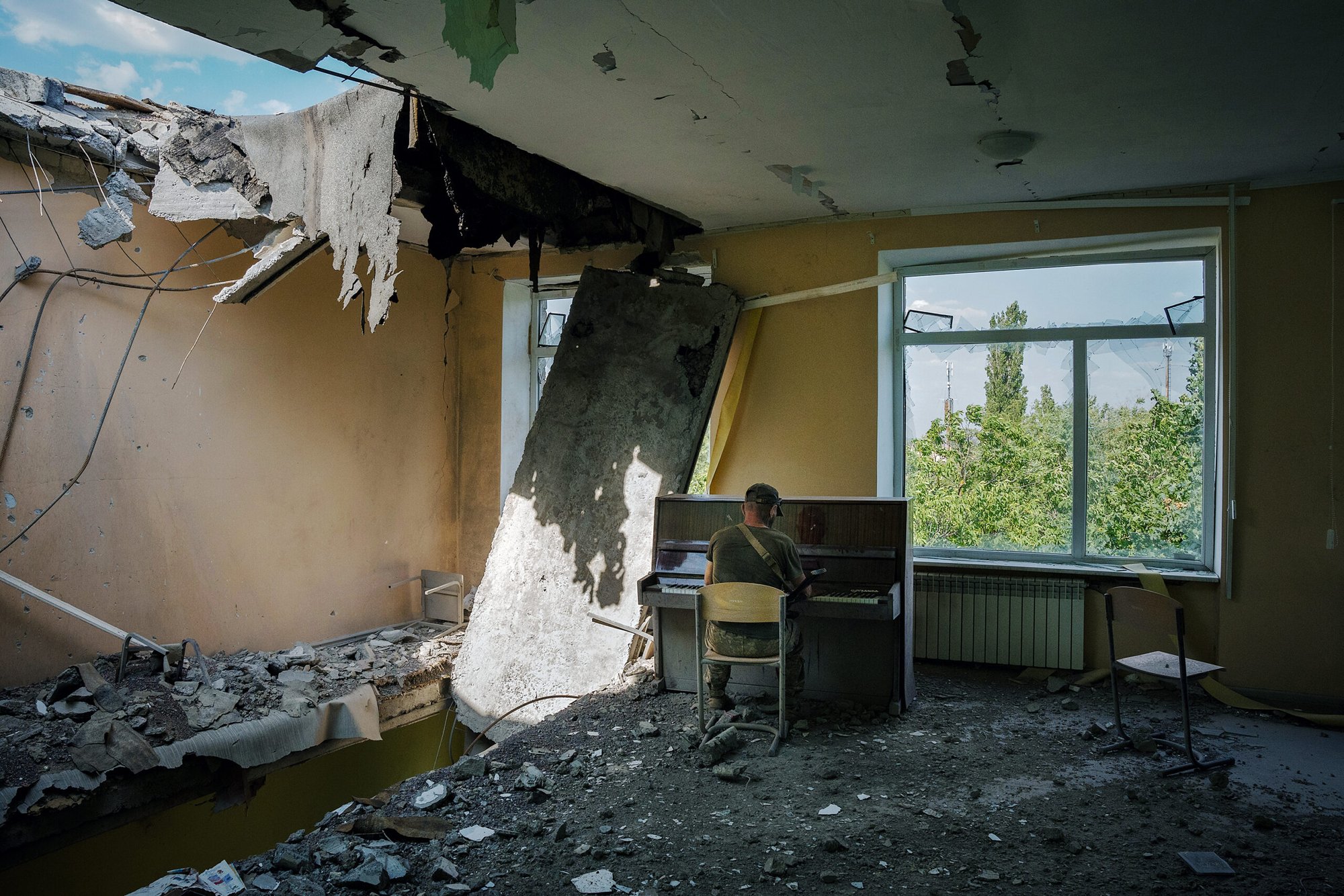 An Ukrainian soldier plays piano in a school destroyed by Russian bombing on the front line in Mykolaiv, Ukraine.