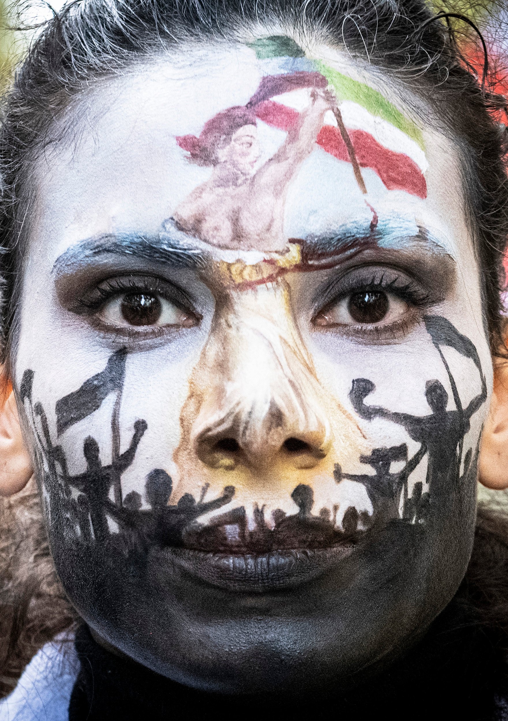 A woman whose entire face is painted like Eugène Delacroix's Liberty Leading the People.