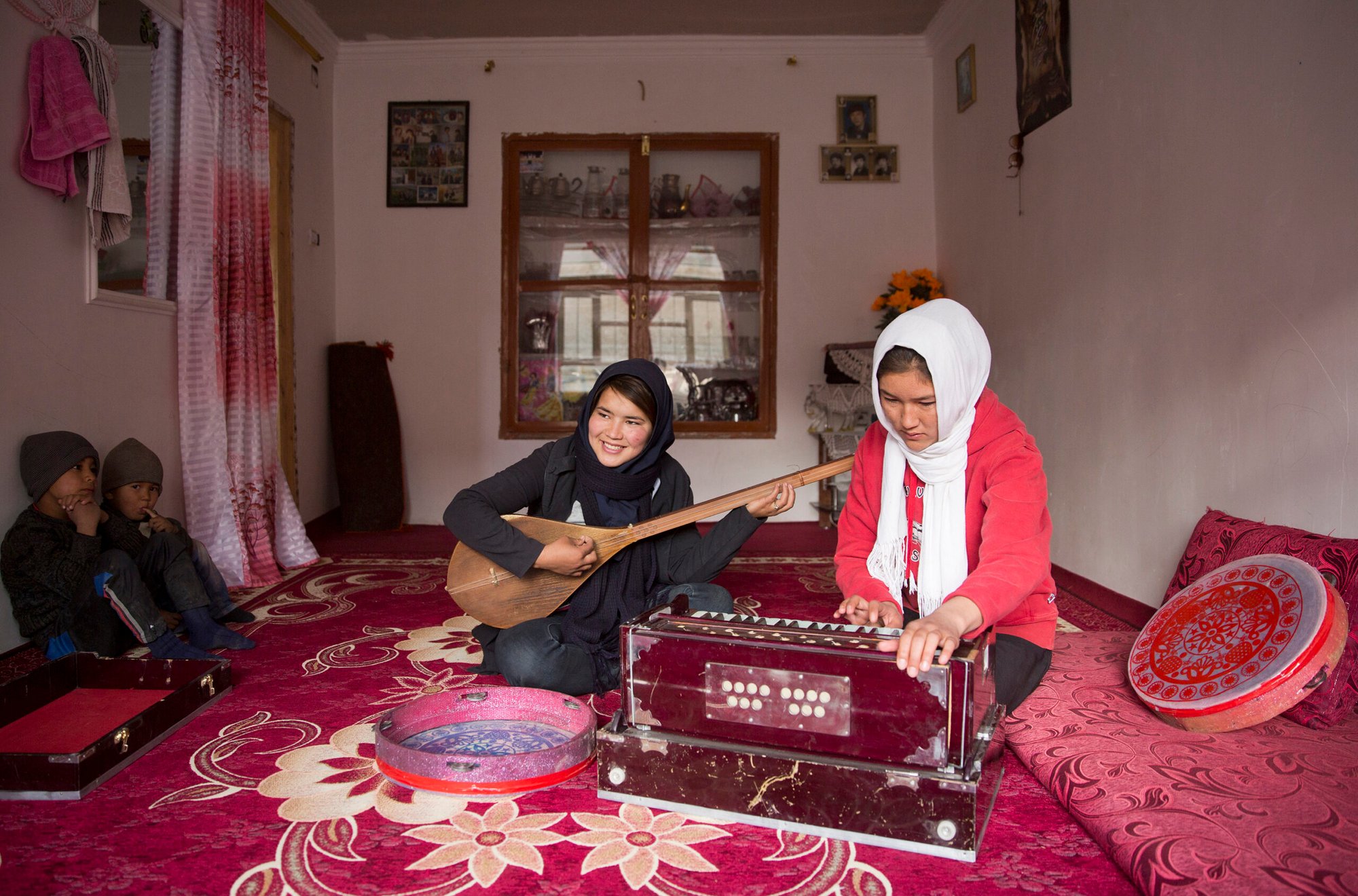 Two Hazara ethnic girls practice Afghanistan's traditional musical instruments at their home in central Bamiyan city.