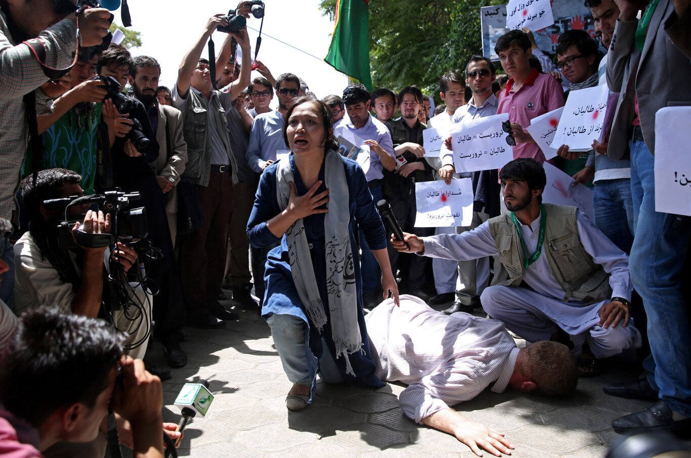 Afghan artists performs a show as members of civil society organizations participate in an anti-Taliban demonstration to rally against "civilians killing" during the holy month of Ramadan, in Kabul, Afghanistan.