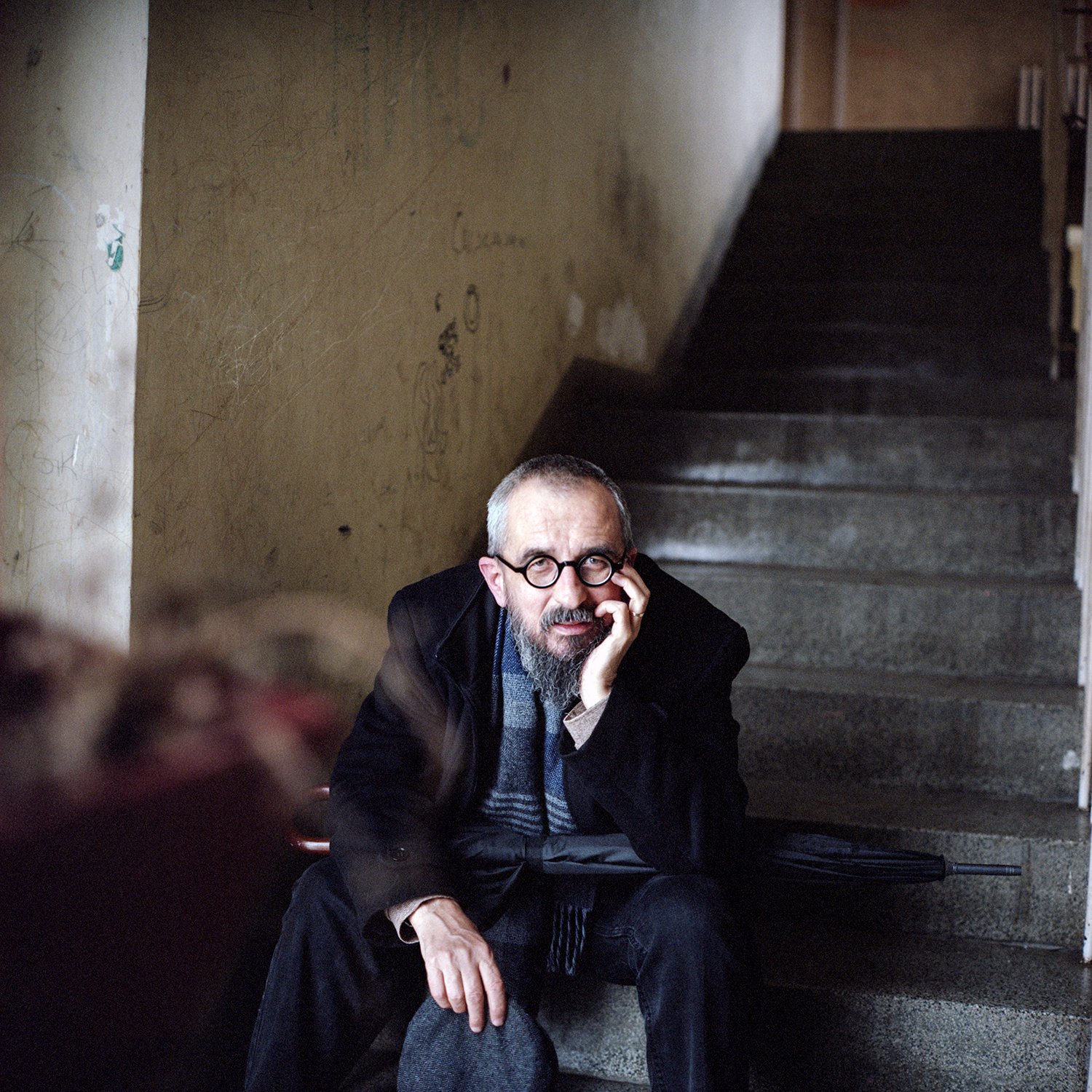 Darko Cvijetić, a Bosnian-Serb writer, filmmaker, and poet, renowned for his novel Schindler Lift, sits on staircase.