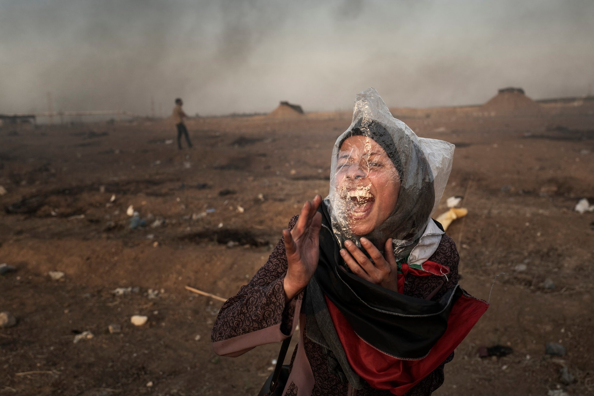 A Palestinian woman protestor wears a plastic bag on her face to protect against tear gas in Gaza, Palestine.