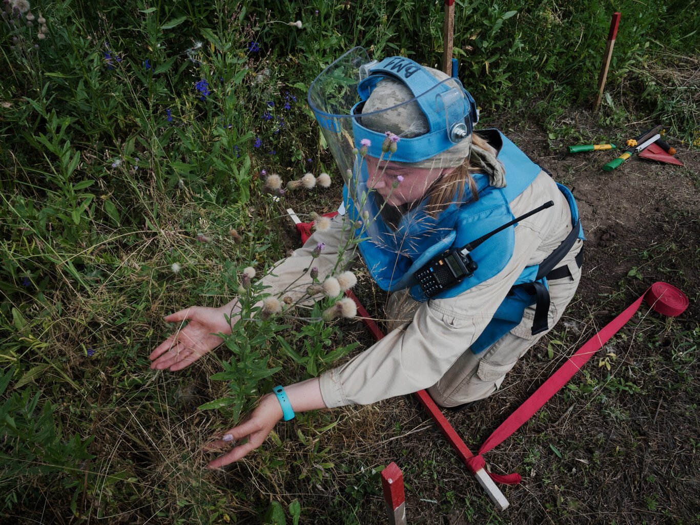 A woman volunteer of Danish Demining Group (DDG) is wears protective suit and inspects landmines in Donbas, Ukraine.