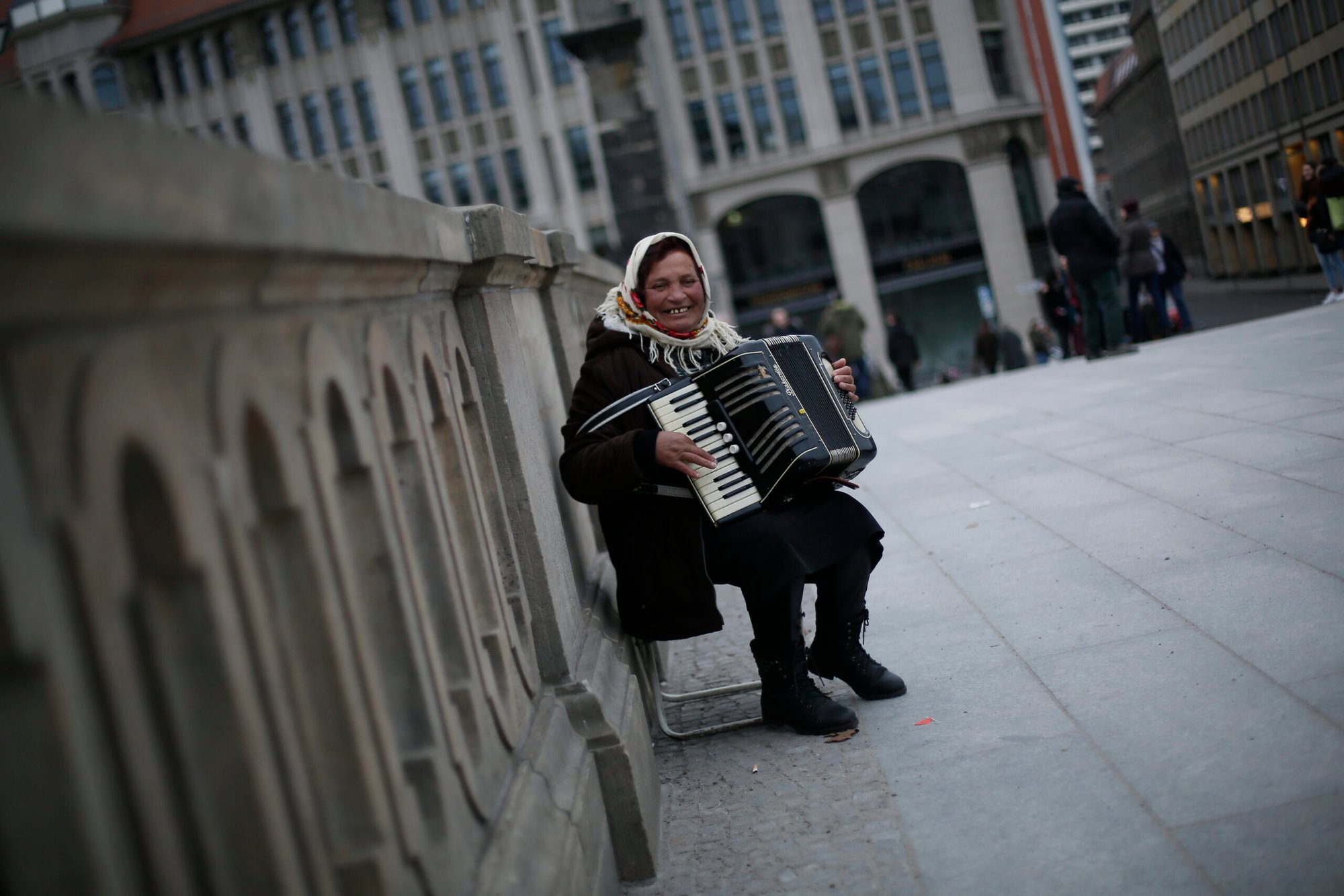 A woman street musician weaves melodies through the streets of Berlin with her accordion.         