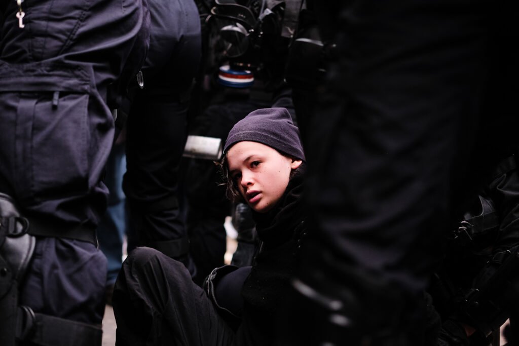 A woman protester in black clothes is carried away by the police in Paris, France.