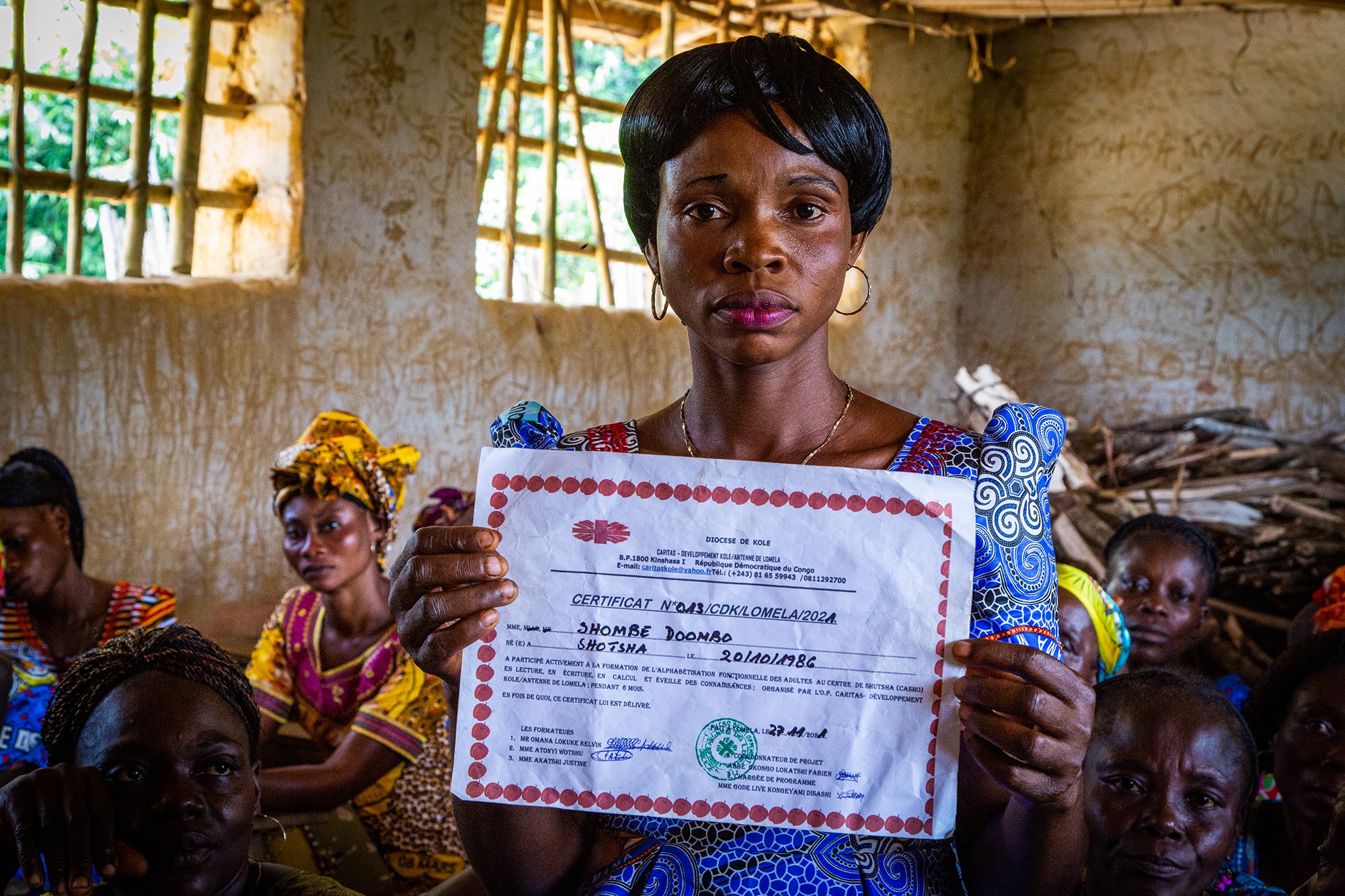 A woman holding a litteracy certificate after completing training program in the Democratic Republic of Congo.