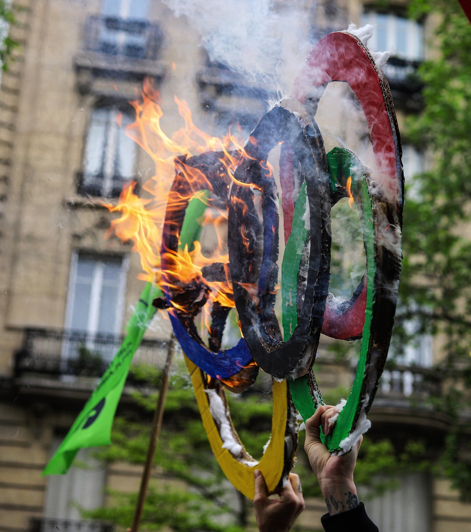 A protester burned the Olympic symbol during a May Day march on the streets of Paris.
