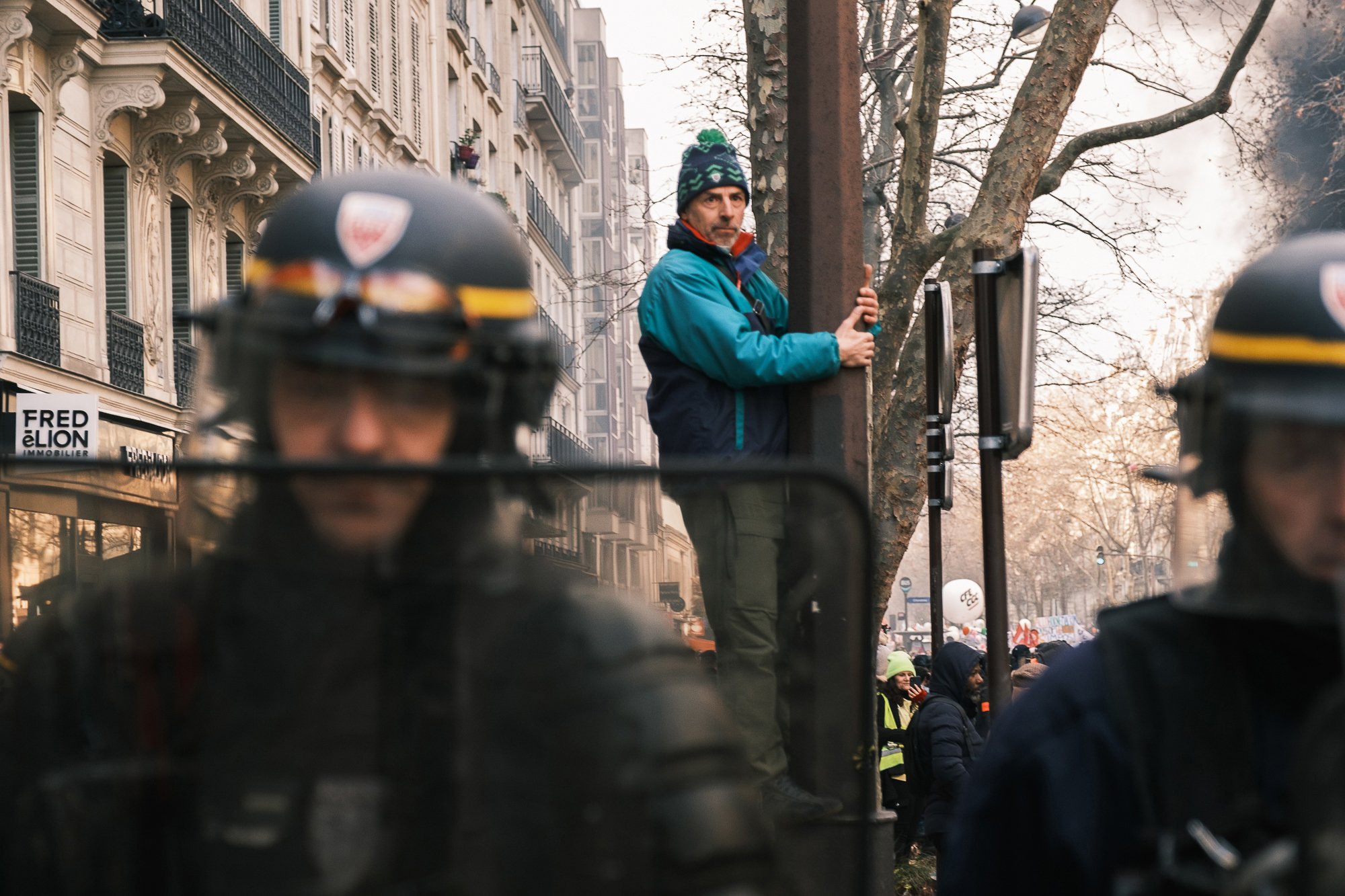  A demonstrator clinging to a tree behind the forces of law and order in Paris, France.