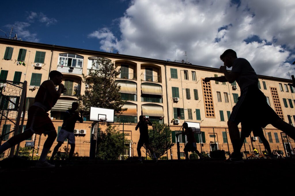 Silhuettes of boxing people at outdoors training in a basketball field in Quarticciolo, Rome.