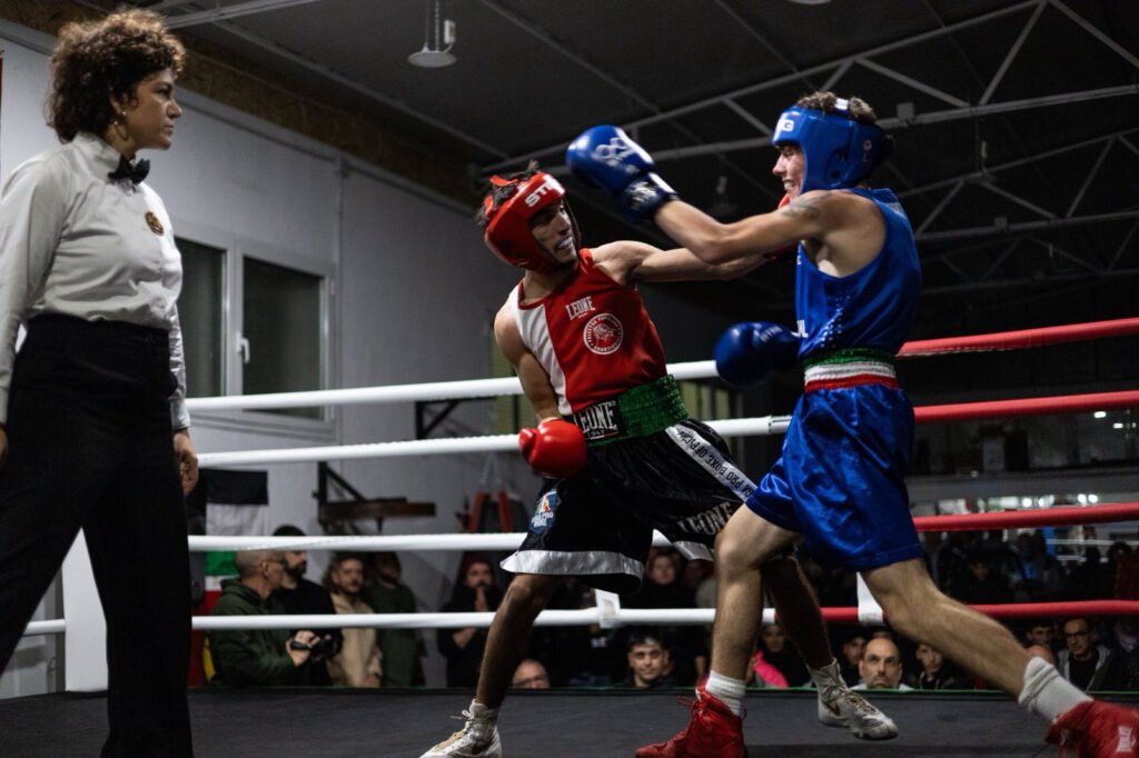 Two boxers exchange hits at Palestra Popolare Quarticciolo boxing ring in Rome, Italy.