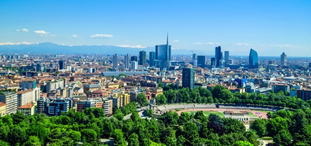 The skyline of Milan with parcon Sempione on the front and the Alps on the background.