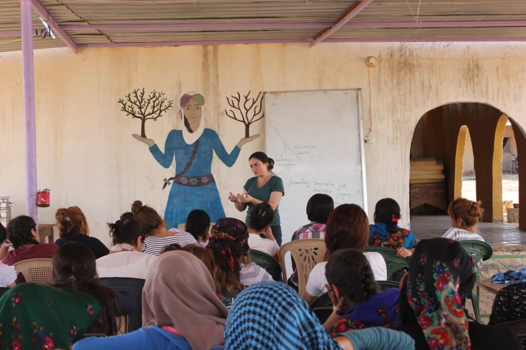 A woman is giving a lesson on jineology in Jinwar village in Rojava.