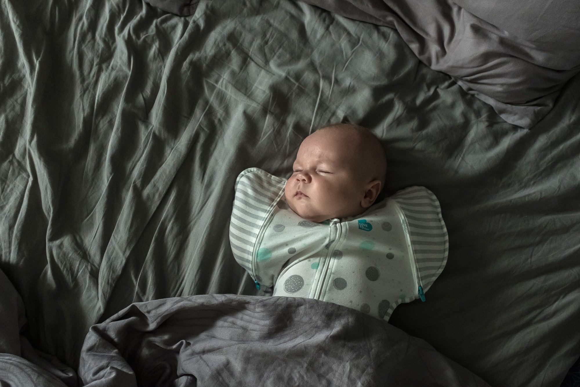 Oksana Parafeniuk and Brendan Hoffman's newborn child, Luka, sleeping on a bed.