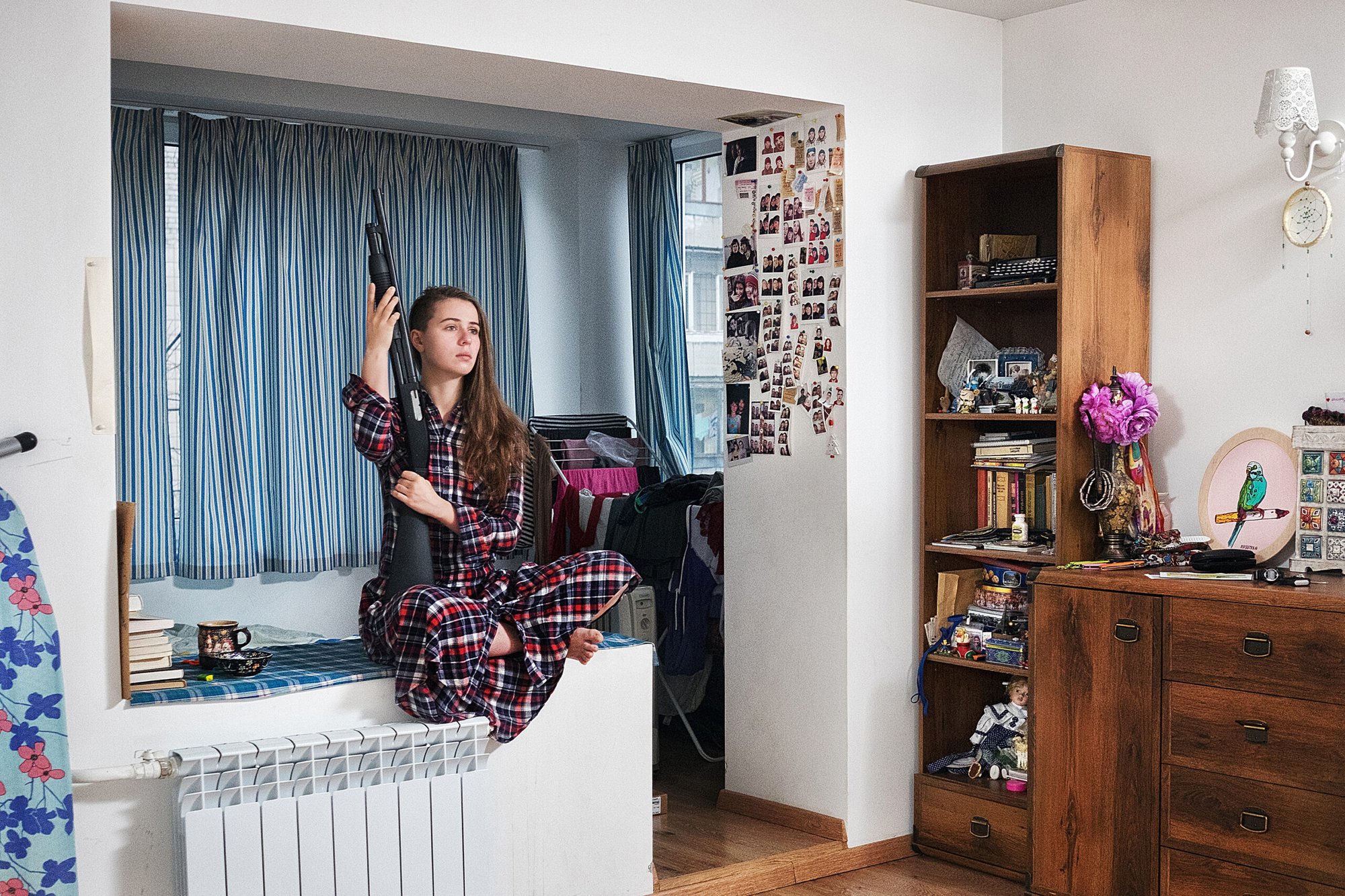 A Ukrainian woman Anastasia poses with a shotgun in her apartment in Kiev.