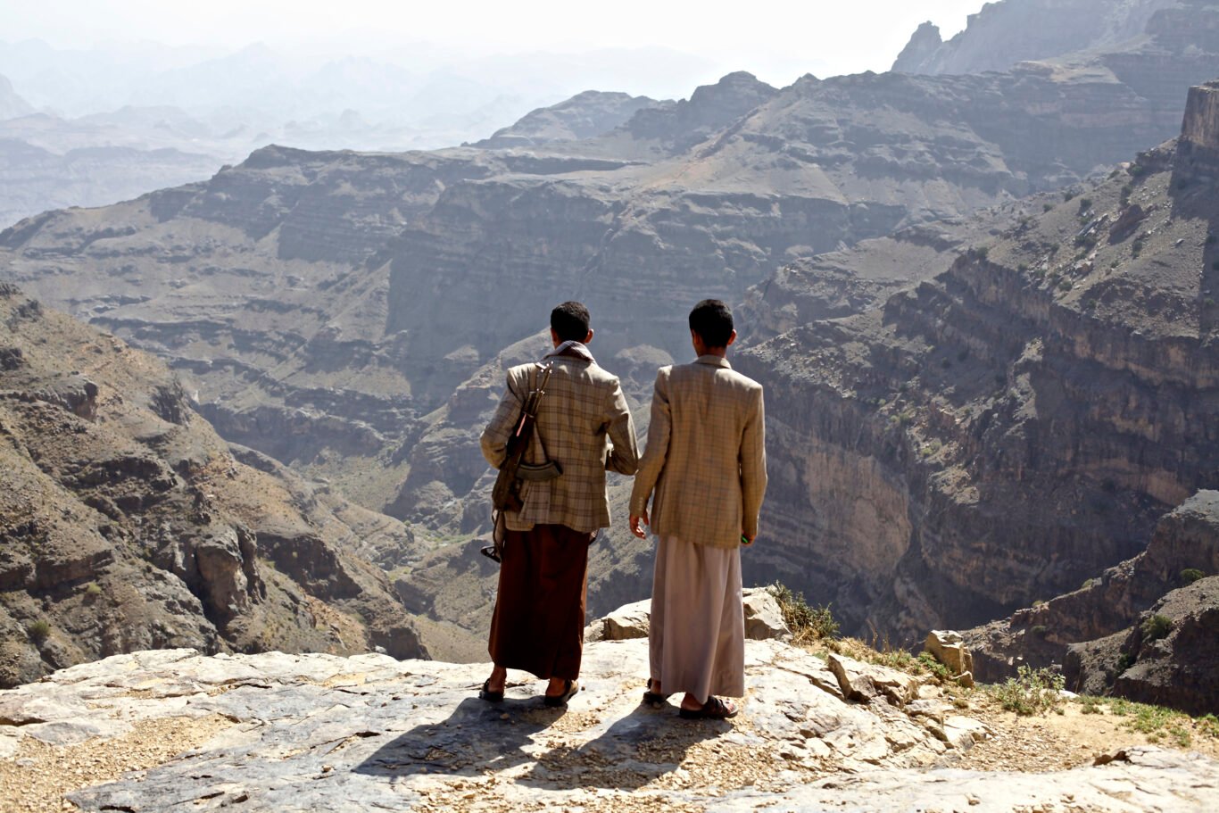 Two young fighters look over the valley in Sanhan and Bani Bahul district of Yemen's Sana'a province.