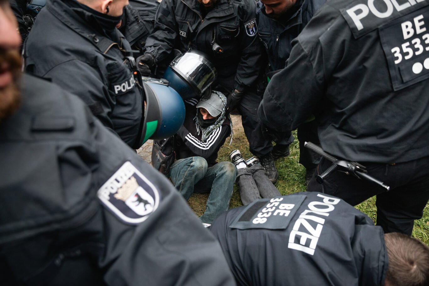 Six police officers are arresting two protesters while evicting a pro-Palestinian camp at the "Freie Universität" in Berlin.