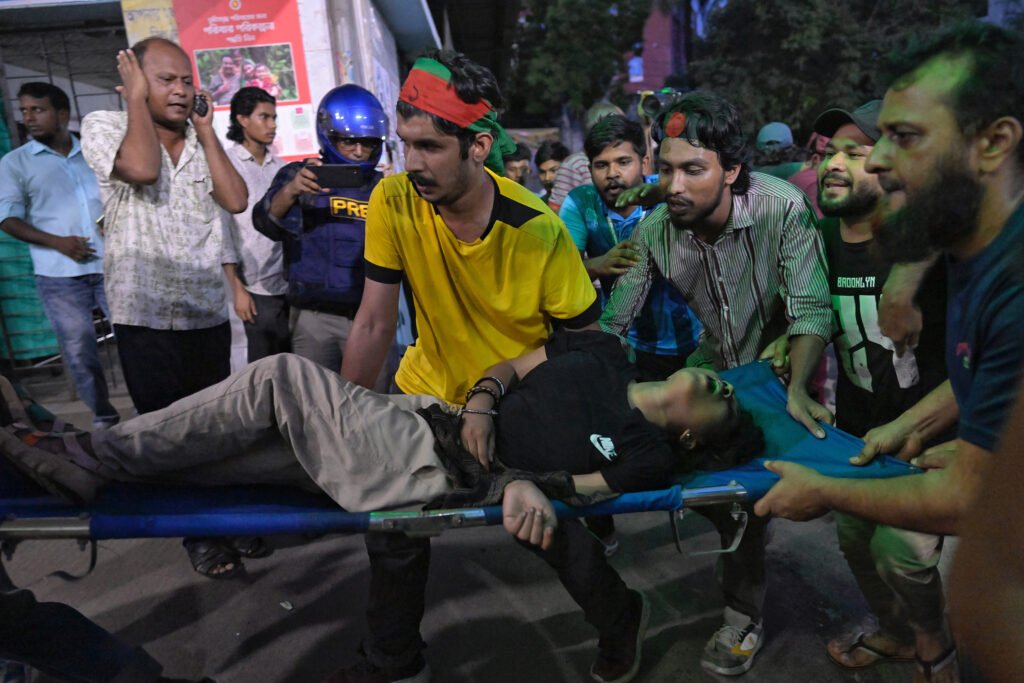 People carry an injured protester to Dhaka Medical College emergency unit after a clash between students and government supporters during a demonstration in Dhaka, Bangladesh.