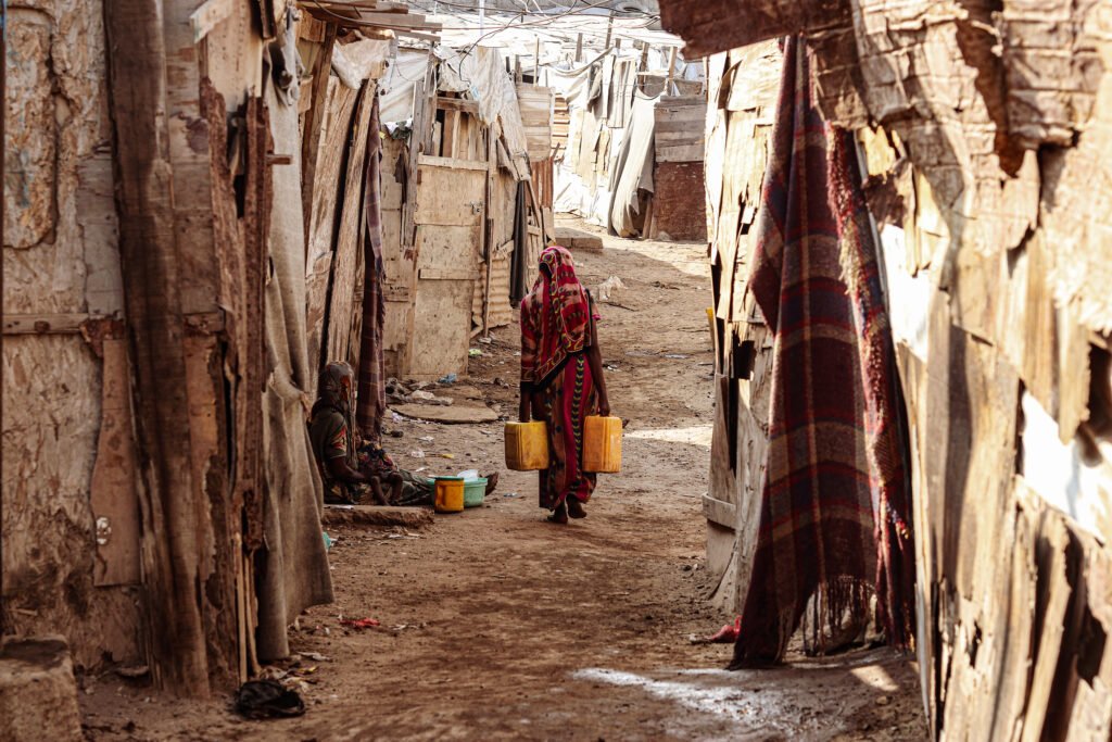 Elderly woman carrying water in a shanty town in Yemen's Aden governorate.