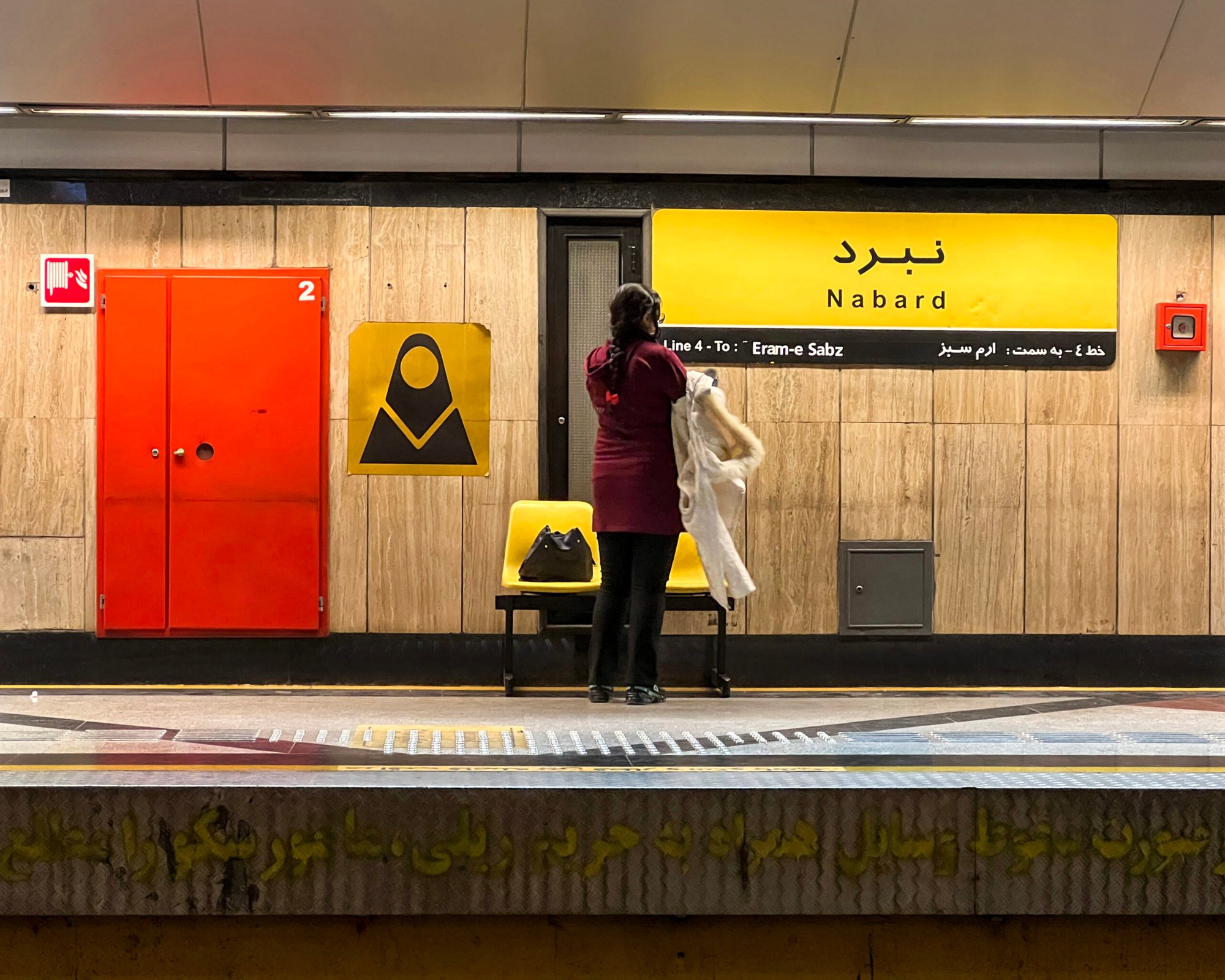 Nabard (Battle) metro station in Tehran woman waits disobeying the hijab rule.