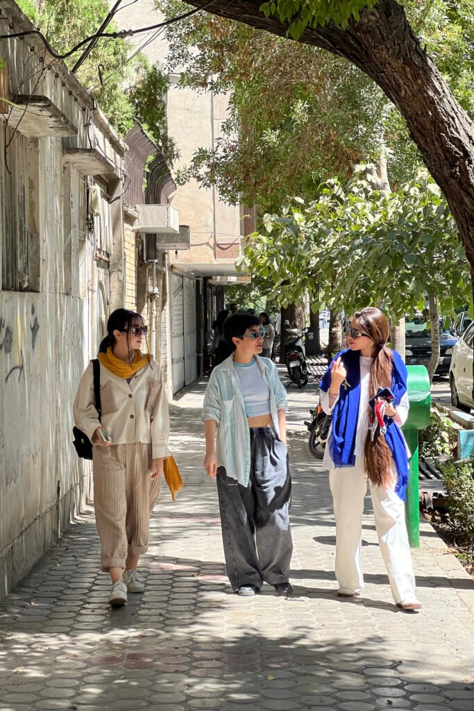 Friends talking on a street in Esfahan, Iran, disobeying the mandatory hijab rule.