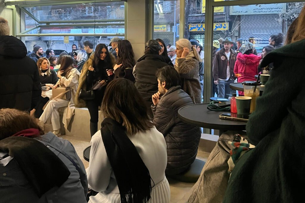 Gallery visitors converse over coffee in downtown Tehran, Iran.