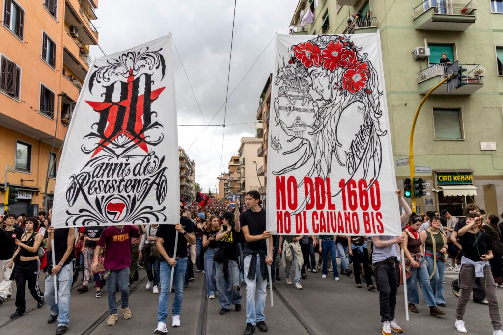Banners from the Partizan collective raised in protest against the security bill, passing in front of the crowd.