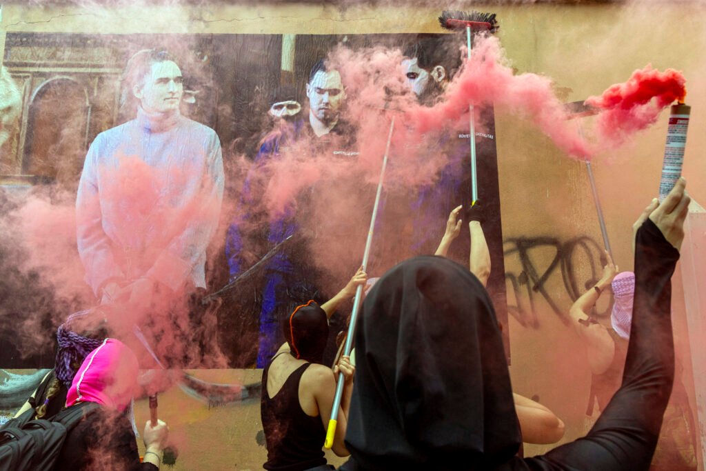 Demonstrators putting up a poster of Maja T. along Via dei Gelsi during the march, featuring an image of her chained during her trial in Hungary. Maja faces 24 years in jail for defending herself against neo-Nazis celebrating the Day of Honor, amid the Hungarian government's ongoing war on anti-fascists.