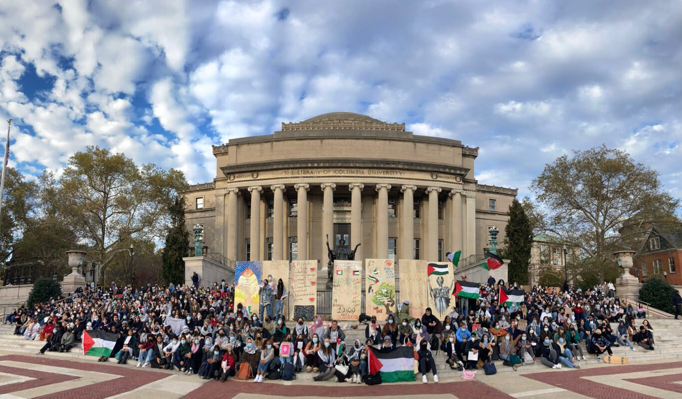 A panoramic view of protesting students surrounding the art installation in front of Columbia University's Low Memorial Library.
