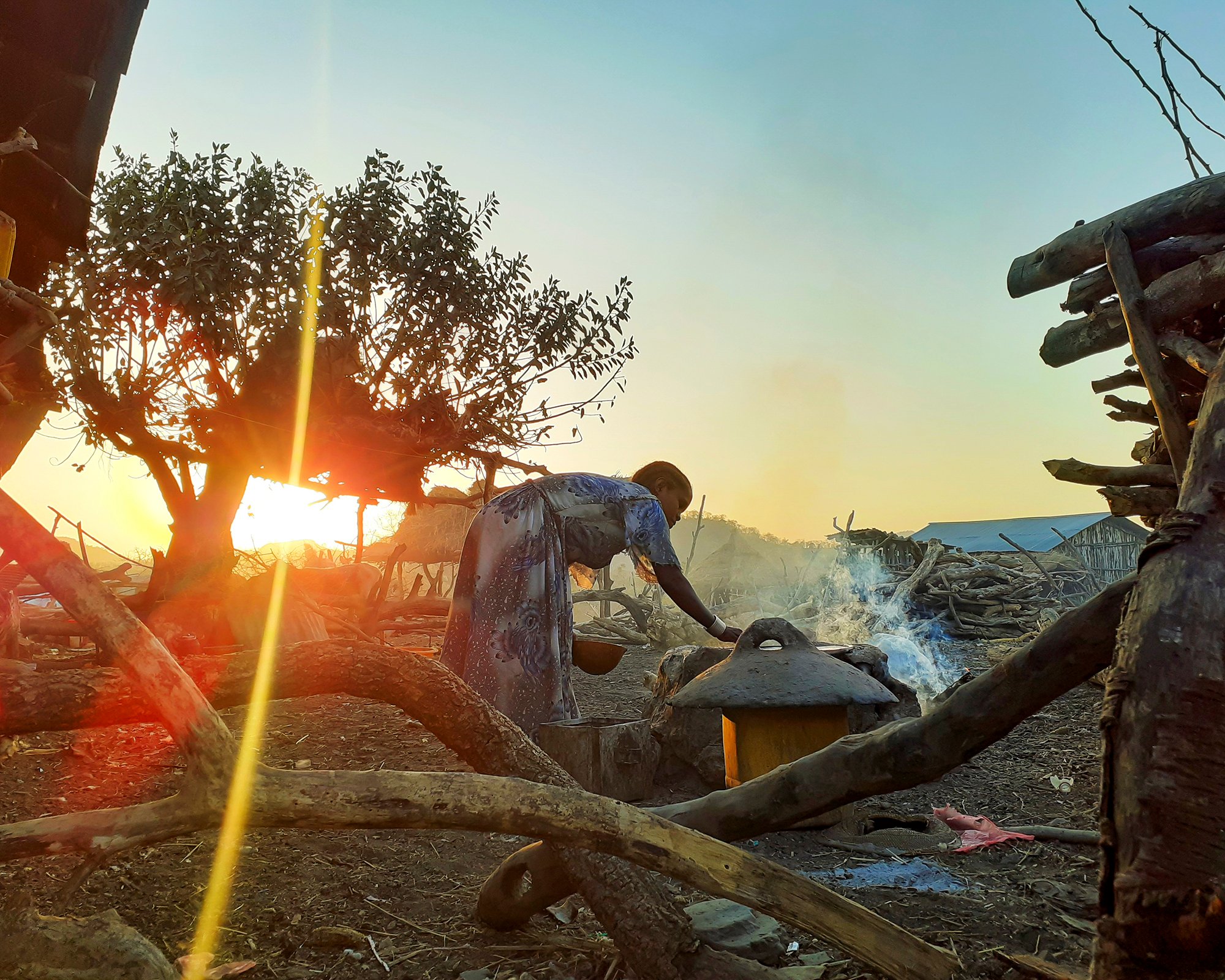 A woman makes injera, Ethiopia’s staple flatbread, as the sun rises in Metema, Ethiopia.