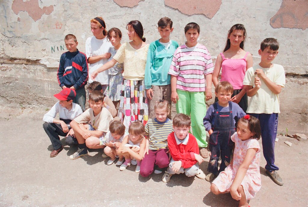 Amel (in the middle with a teal T-shirt) and Džemil (far right in a yellow T-shirt) in their neighbourhood photo from Thomas James Hurst.