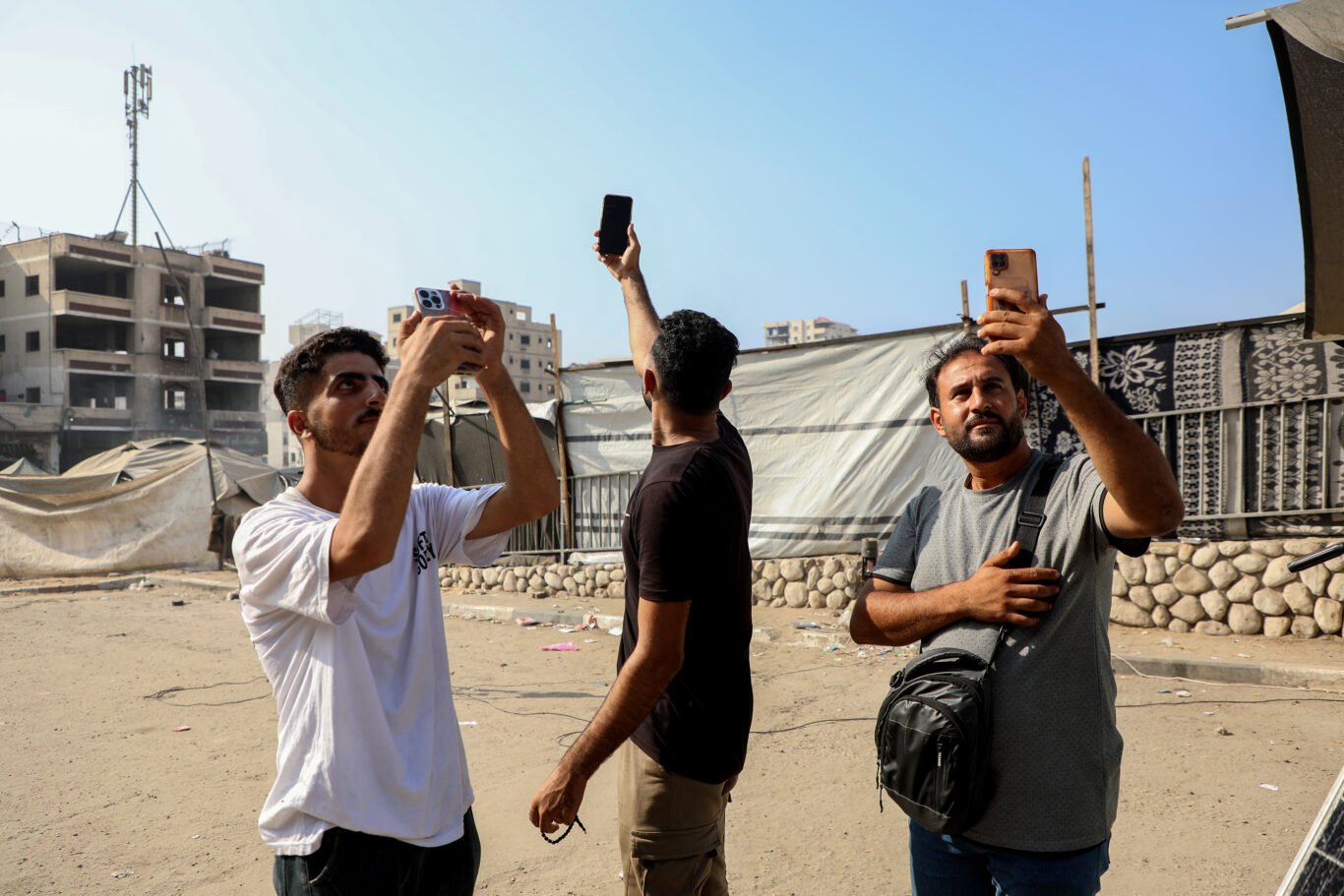Palestinian journalists in Gaza City are trying to pick up a Wi-Fi signal to continue their work.